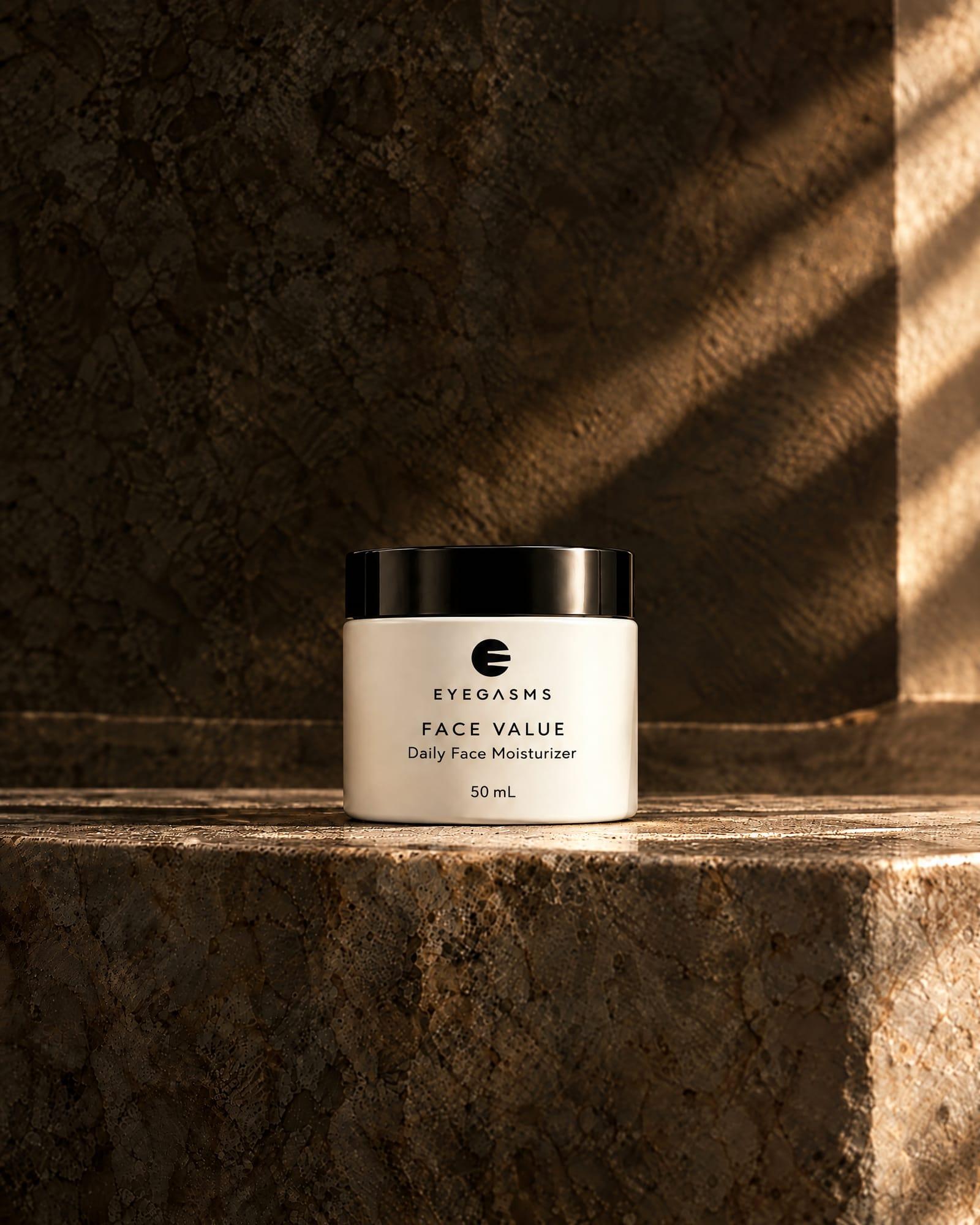 Face Value, daily face moisturizer, by EYEGASMS: a bone jar with a glossy black lid, 50 mL, alone on a travertine ledge in raking golden light.